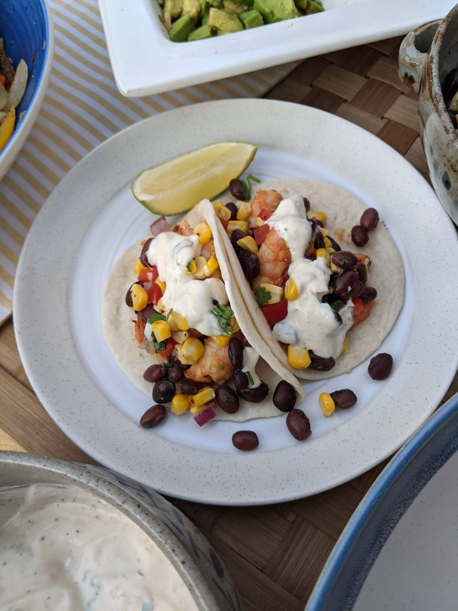 shrimp taco with grilled corn and black bean salsa and lime cilantro sauce